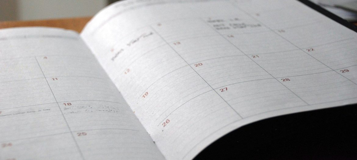 open monthly planner on wooden desk