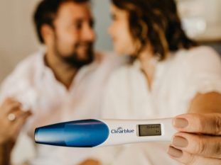 man in white dress shirt holding blue and white digital thermometer