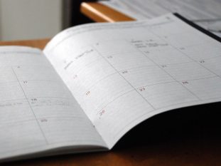 open monthly planner on wooden desk