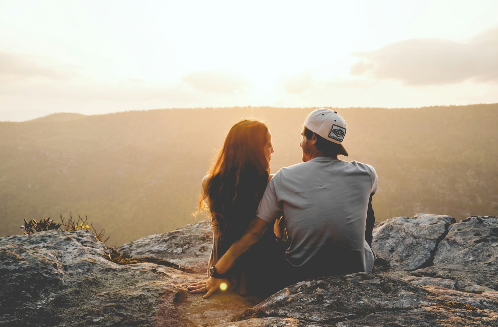 Photo by Cody Black man and woman sitting on rock during daytime