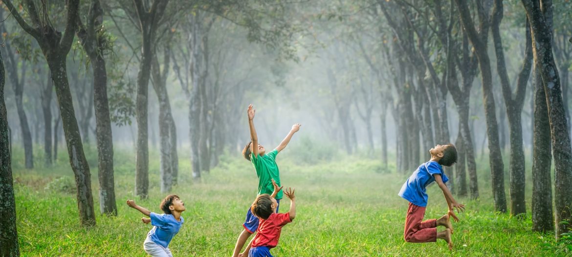 Photo by Robert Collins four boy playing ball on green grass