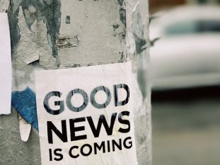 white Good News Is Coming paper on wall